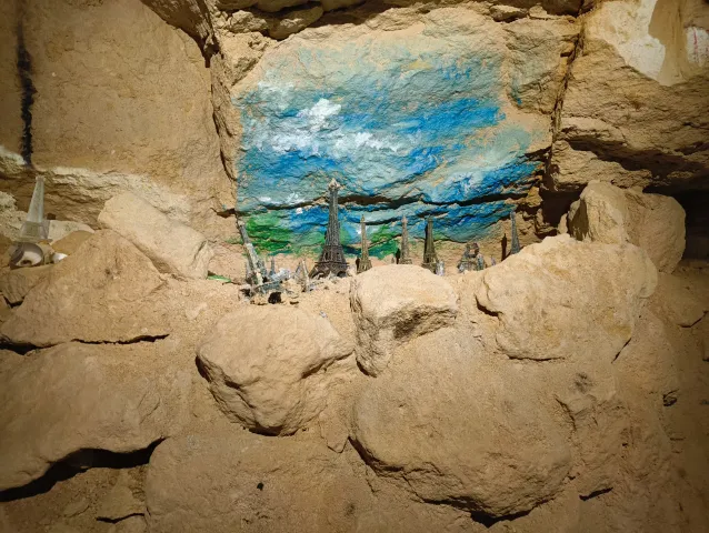 Fresque de ciel nuageux peinte au fond d'une niche, encadrée par des blocs de calcaire
