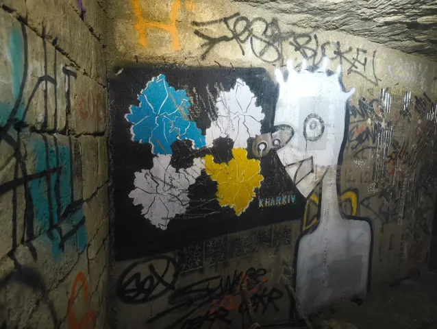 Panneau noir orné de feuilles stylisées bleues, blanches et jaunes, entouré de tags