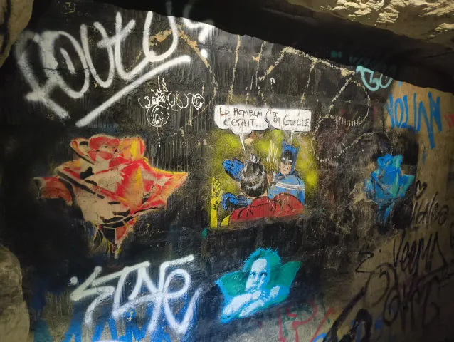 Mur noir couvert de personnages de bande dessinée et de bulles de dialogue peints